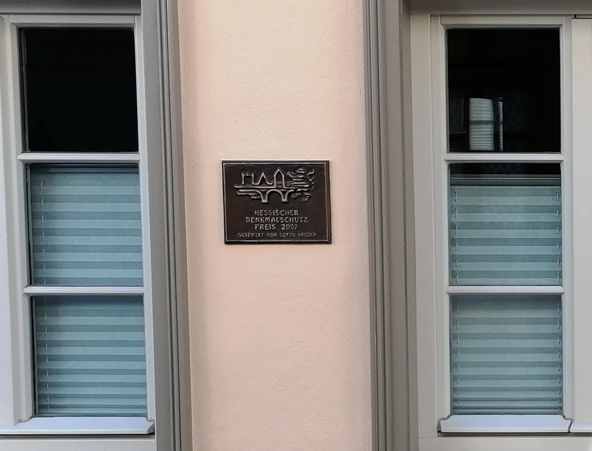 Plakette mit Hessischem Denkmalschutzpreis - die Auszeichnung zwischen zwei PaX Sprossenfenstern