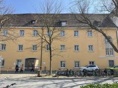 historisches Gebäude gelbe Fassade Holzfenster Rundbogenfenster Denkmalschutz Schule