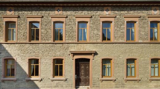 Bruchsteinfassade eines historischen Wohnhauses mit neuen Holzfenstern von PaX