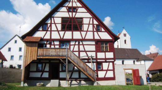 historisches Fachwerkgebäude rote Balken saniert Denkmalschutz Holzfenster 