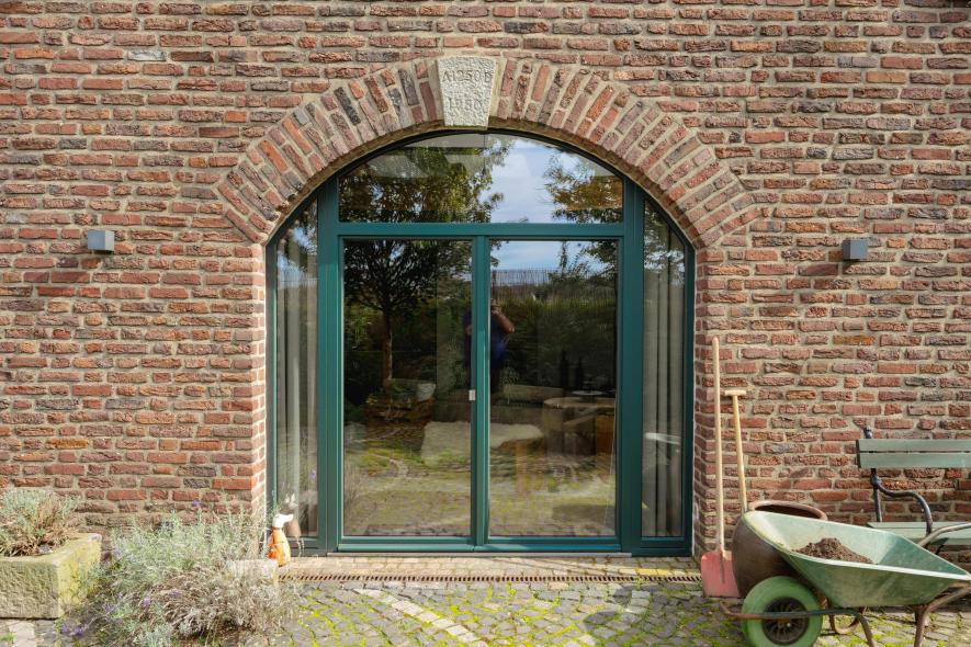 Grüne Terrassentür in altem Bauernhaus