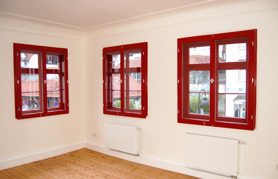 Rote Fenster aus Holz im Altbau mit Denkmalschutz