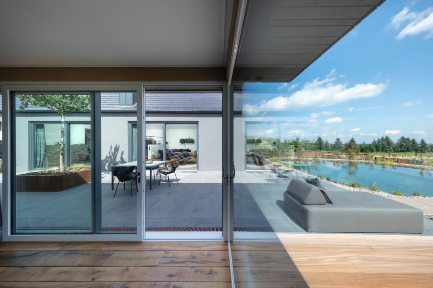 Zwei gegenüberliegende Hebeschiebetüren aus Holz-Aluminium in modernem Wohnhaus