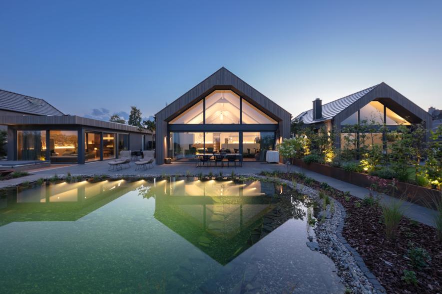 Die Wohn und Ferienanlage mit Holz-Aluminium Fenstern im Abendlicht