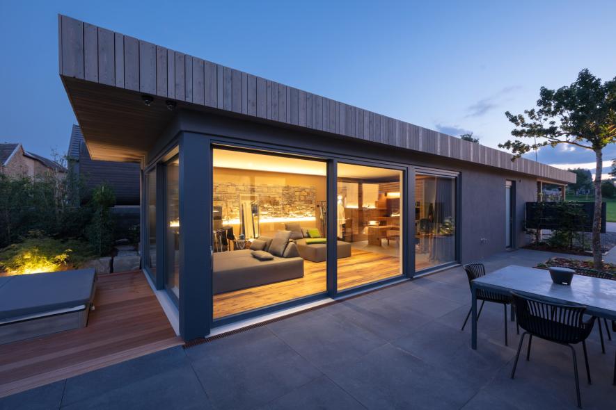 Das Wohnhaus  mit Holz-Aluminium Fenstern im Abendlicht