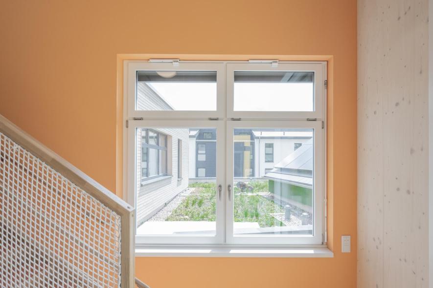 Zweiflügeliges Holz-Aluminium-Fenster mit Oberlichtern im Treppenhaus der Kita Sträßchen in Burscheid