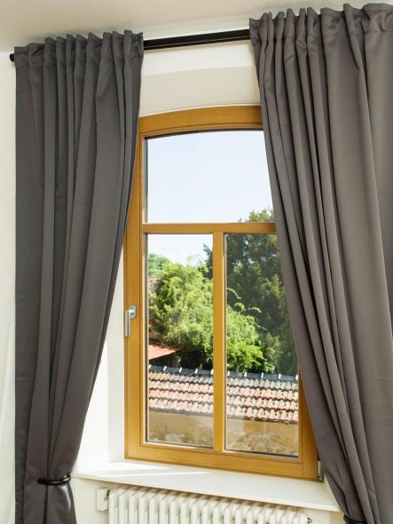 Holzfenster mit anthraziten Vorhängen