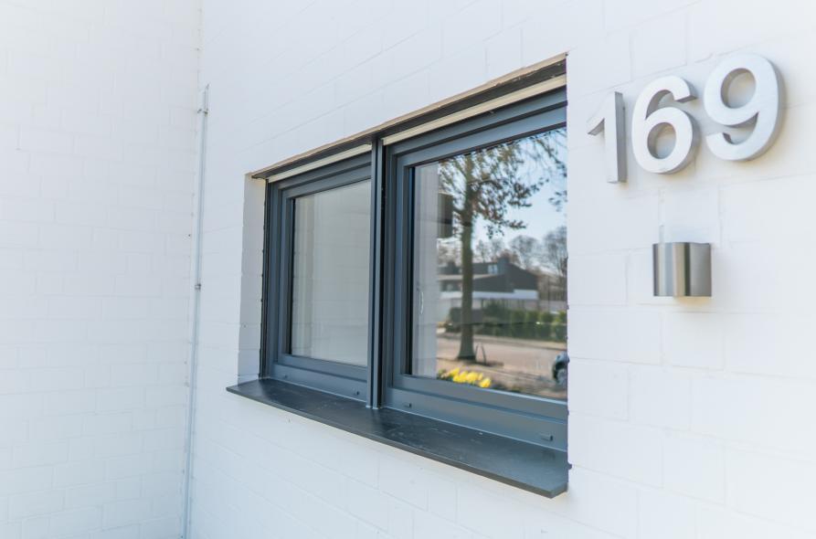 Der dunkelgraue Farbton der Fenster sorgt für einen schönen Kontrast zur weißen Fassade