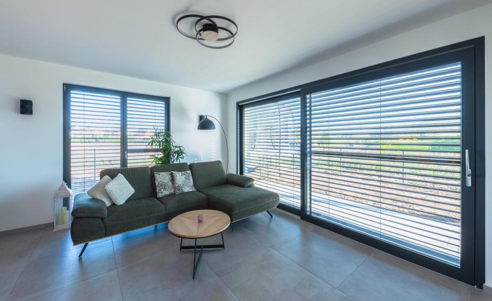 Die großzügigen Hebeschiebetüren im Wohnzimmer sind innen und außen anthrazit foliert.