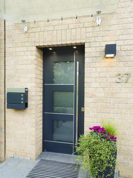 Die anthrazitgraue Haustür steht in einem schönen Kontrast zur hellen Fassade