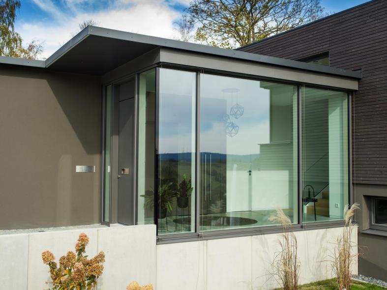 Der großzügig verglaste Hausflur lässt viel Tageslicht ins Haus