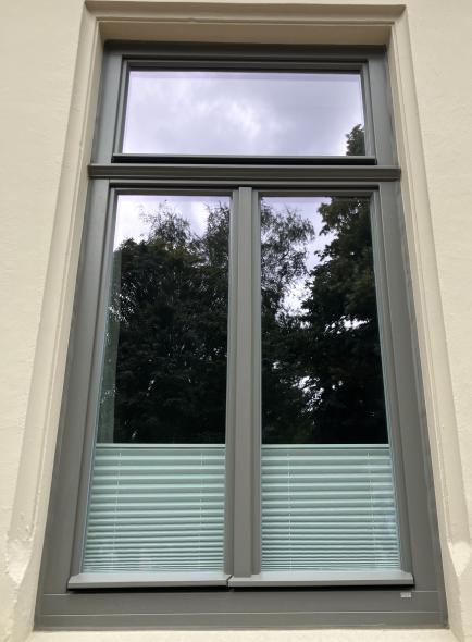graues Holzfenster mit Zierprofilen Denkmalschutz Norddeutschland 