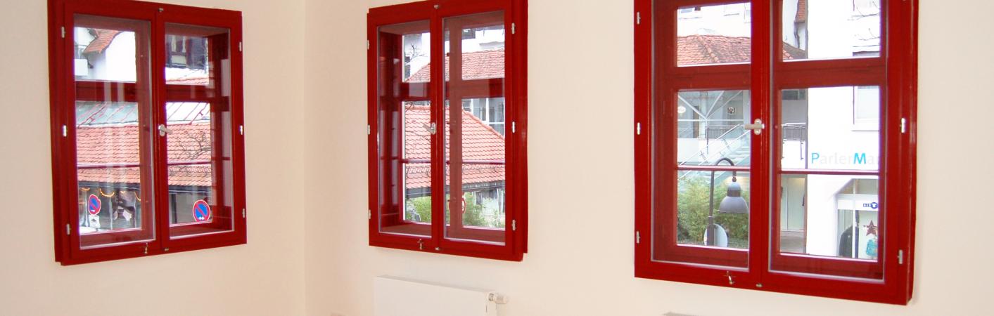 Rote Fenster aus Holz im Altbau mit Denkmalschutz