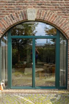 Grüne Terrassentür in altem Bauernhaus