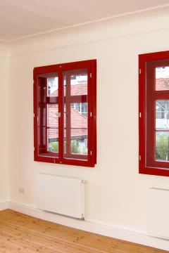 Rote Fenster aus Holz im Altbau mit Denkmalschutz